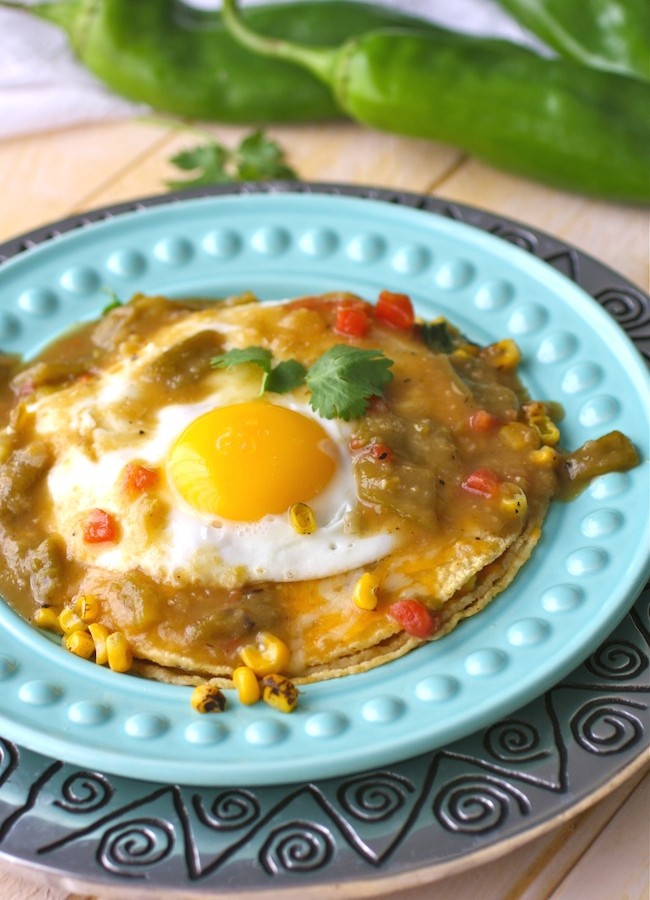 A plate of stacked enchiladas with an egg on top