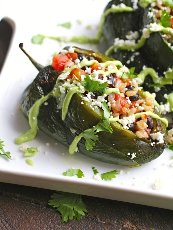 Black Bean and Rice Stuffed Poblano Peppers with Avocado Cream are warm and filling, and a great meatless dish.