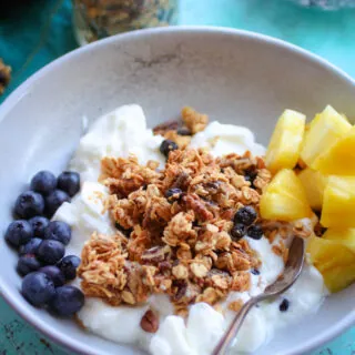 Homemade Granola with Blueberries and Pecans in a bowl with yogurt and fresh fruit makes an ideal breakfast!