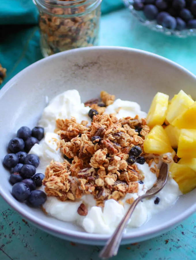Homemade Granola with Blueberries and Pecans in a bowl with yogurt and fresh fruit makes an ideal breakfast!