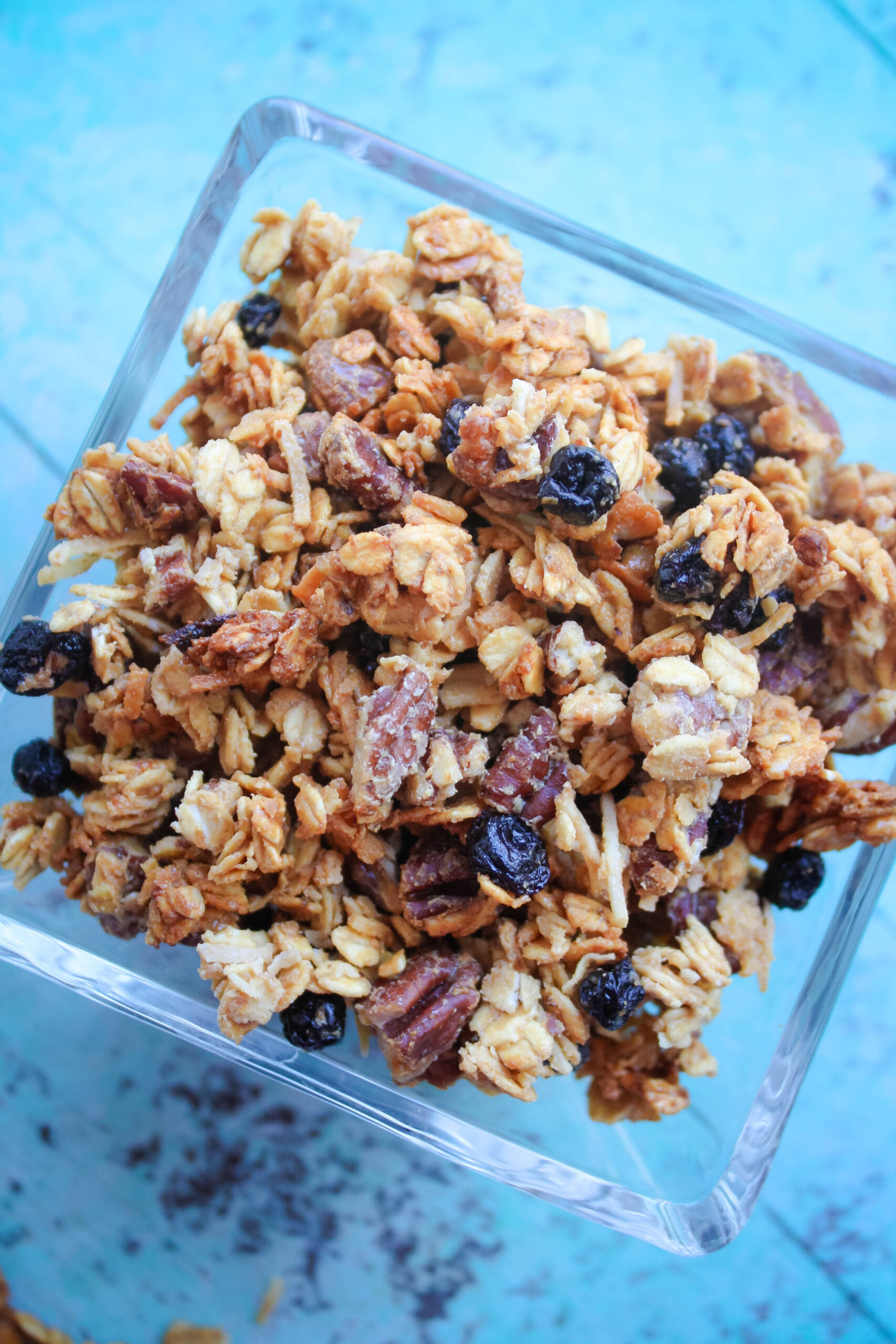 Looking down on a bowl of granola filled with blueberries and pecans