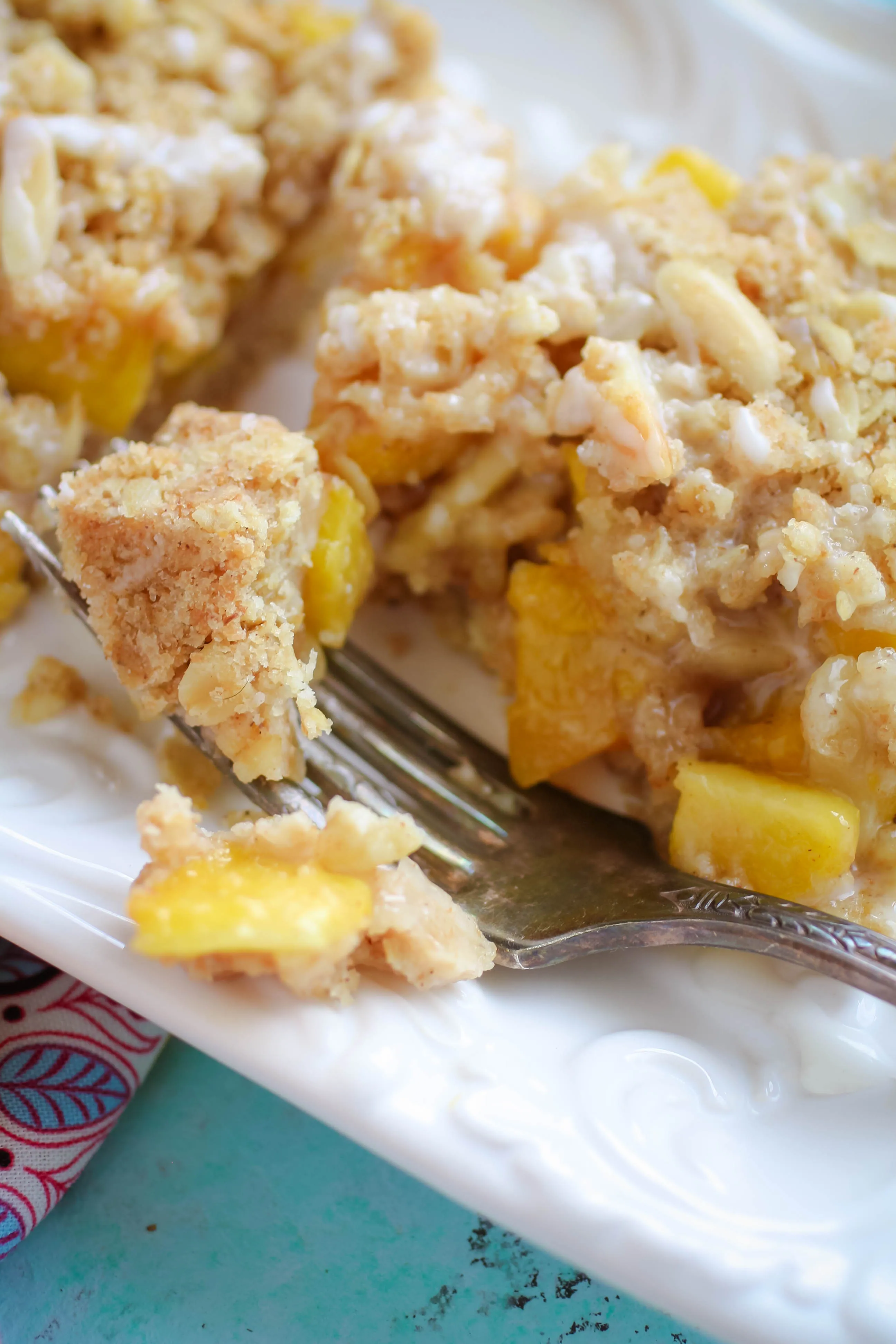 Peach Crumble Squares with Bourbon Glaze are a summertime treat to dig into. Enjoy these Peach Crumble Squares with Bourbon Glaze this summer while peaches are in season.