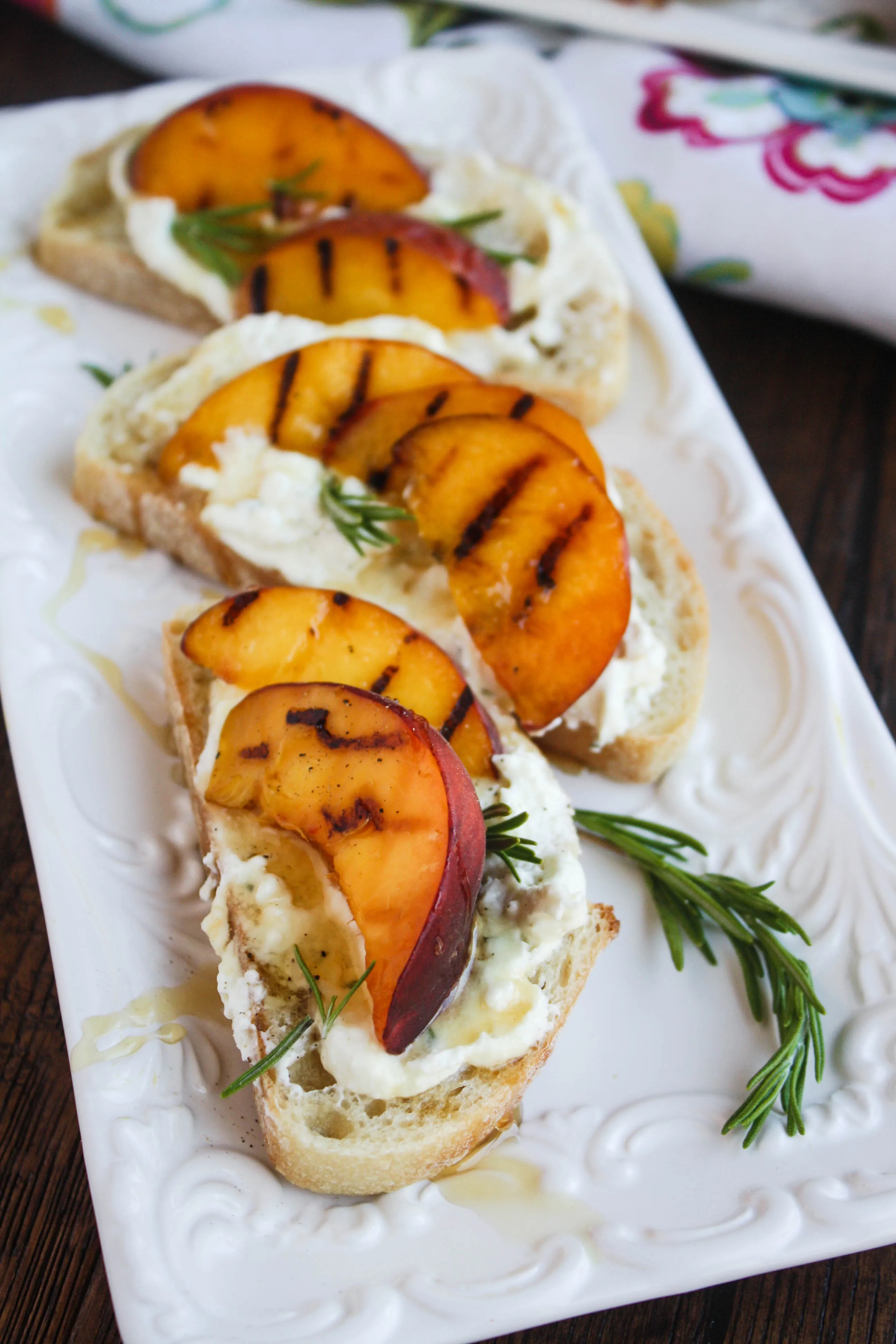 Rosemary Whipped Feta with Grilled Peaches and Honey is a lovely, cheesy appetizer. Serve it at your next party!