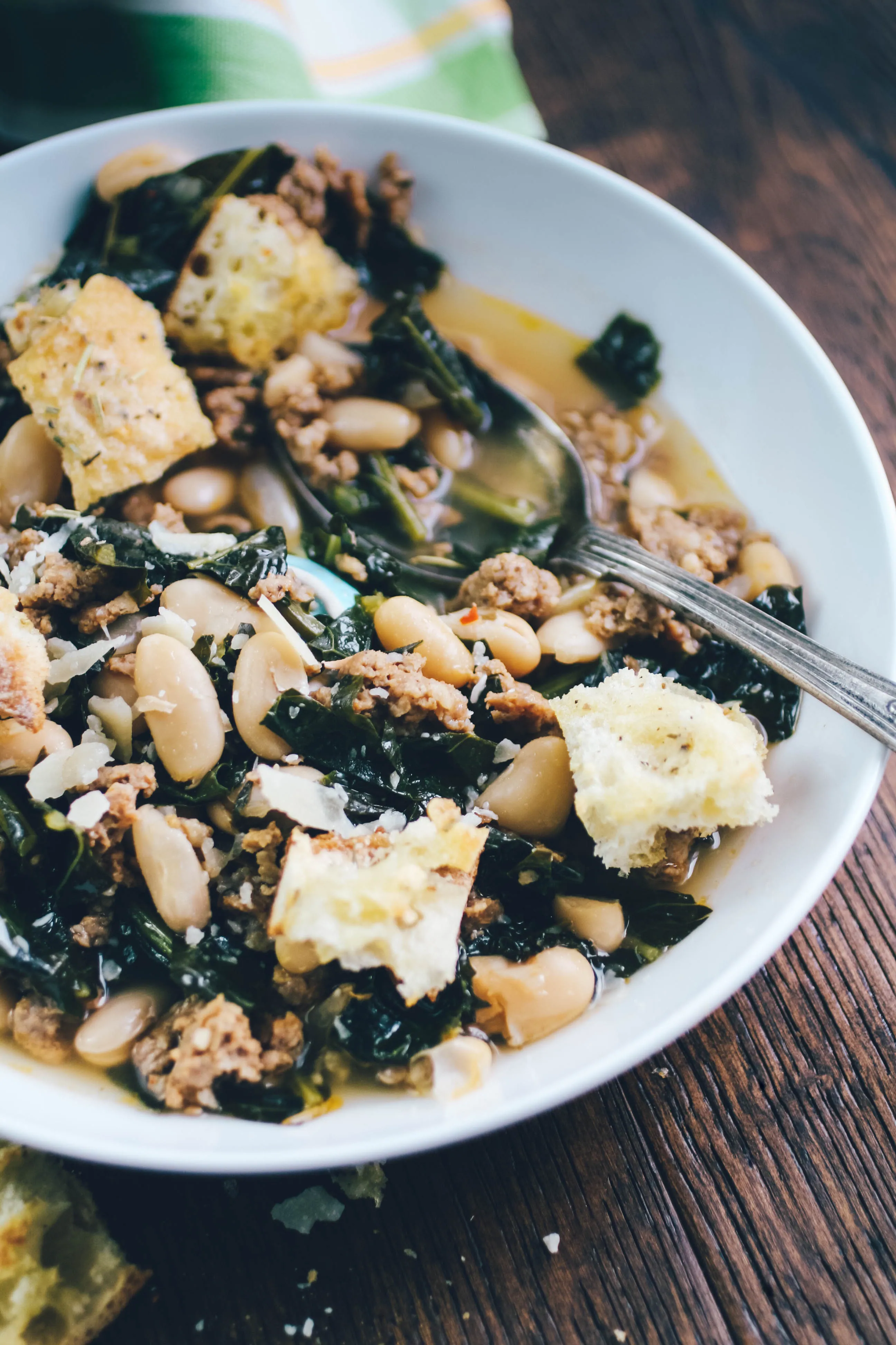 Sausage, Kale, and White Bean Soup with Rosemary-Parmesan Croutons is a dish for any night of the week. Sausage, Kale, and White Bean Soup with Rosemary-Parmesan Croutons is easy to make and it's super-satisfying! Make a batch of Sausage, Kale, and White Bean Soup with Rosemary-Parmesan Croutons tonight!