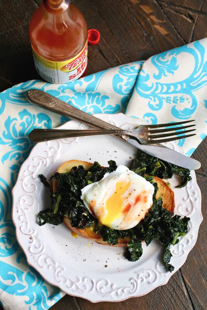 Sauteed Kale on Toast with Poached Eggs is delicious! Add a little hot sauce to make this breakfast dish even better!