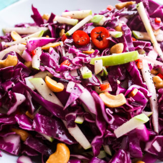 A big bowl of Simple Cabbage Salad with Poppyseed Dressing offers color and crunch thanks to the purple cabbage, apple, and cashews!