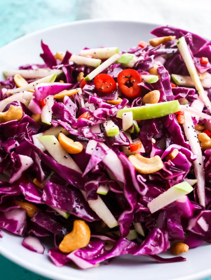 A big bowl of Simple Cabbage Salad with Poppyseed Dressing offers color and crunch thanks to the purple cabbage, apple, and cashews!