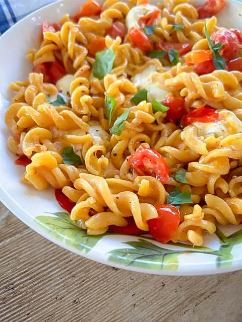 You'll love Simple Warm Caprese Pasta for your next meal. It's easy to make with a handful of fresh, flavorful ingredients.