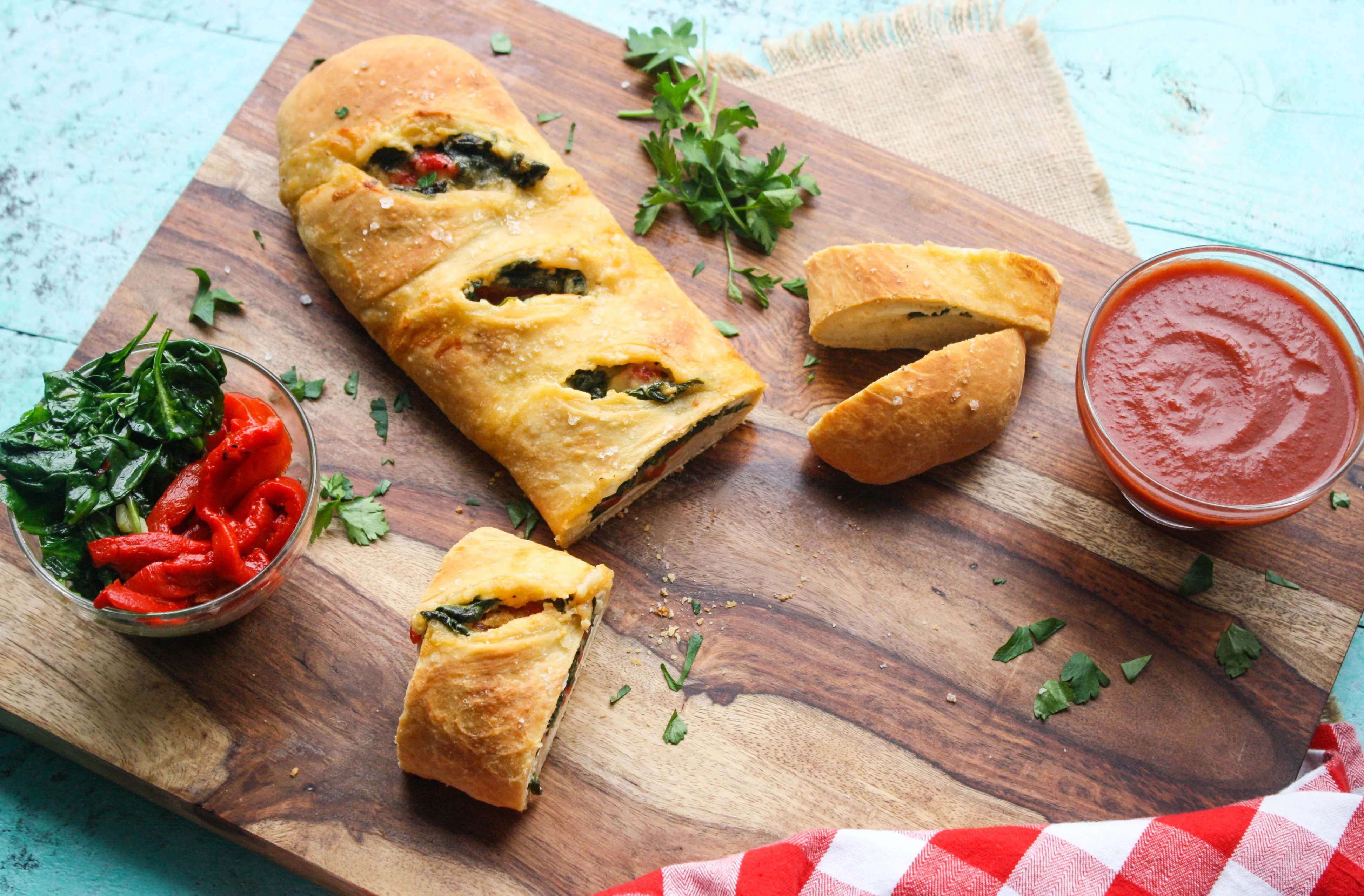 Spinach and Roasted Red Pepper Stromboli is filled with delicious ingredients and it's so fun to serve! You'll love this pizza-like dish.