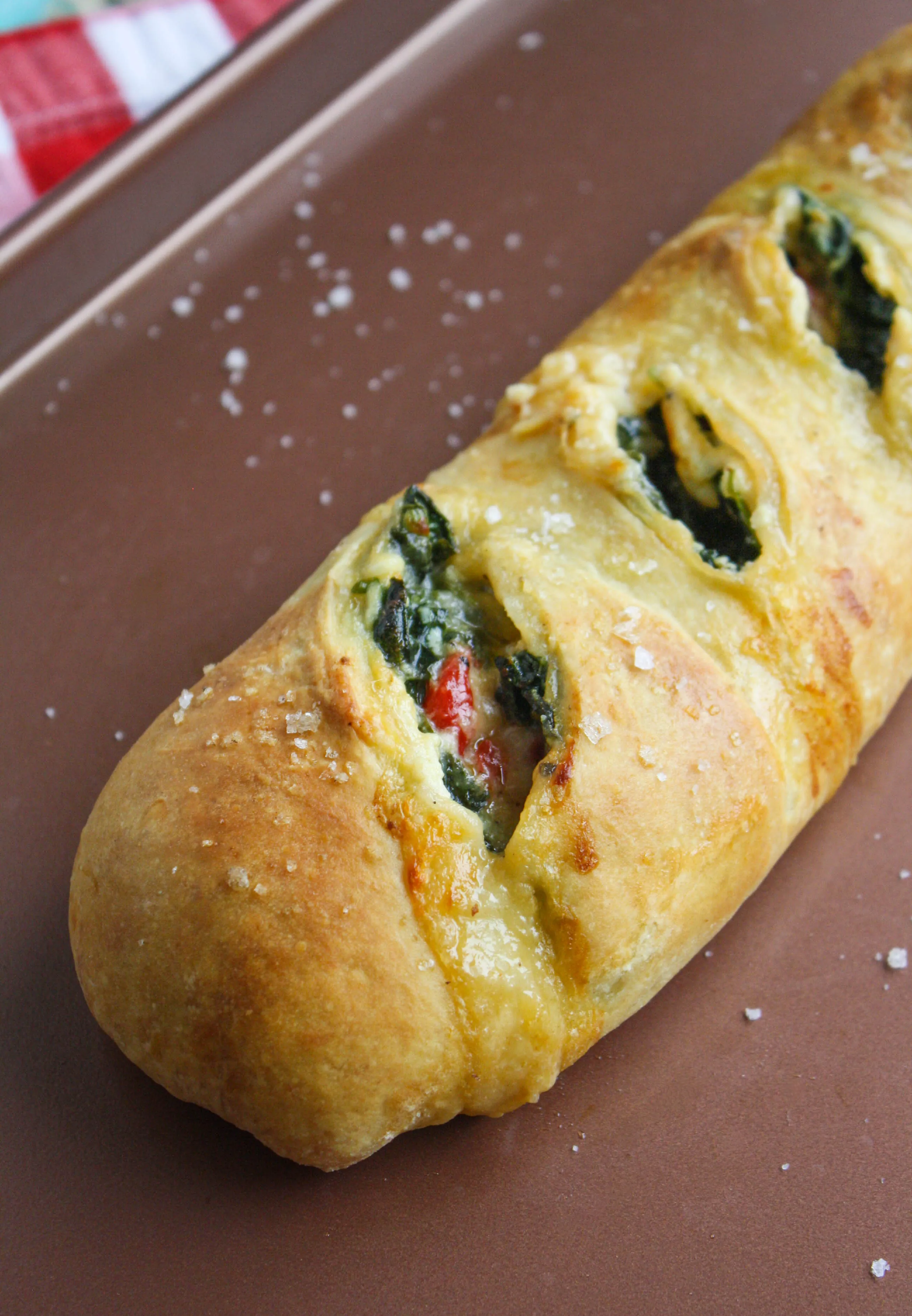 Spinach and Roasted Red Pepper Stromboli is baked until beautifully golden and severed warm for a delicious dish. Stromboli is a dish you'll love any night of the week!