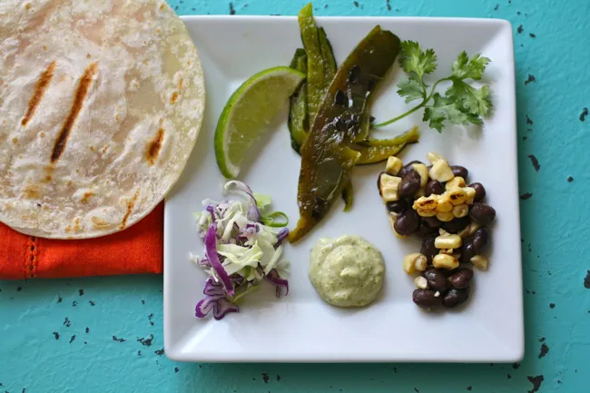 A plate of Grilled Corn, Peppers & Black Bean Tacos,Taco ingredients