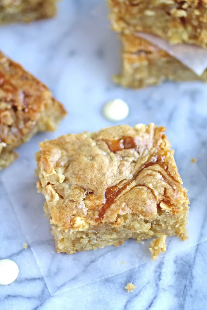 A ribbon of caramel, apple bits, and white chocolate chips combine to make Caramel Apple and White Chocolate Chip Blondies!